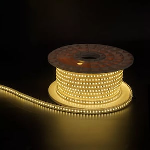May include: A spool of warm white LED strip lights. The lights are wound around a brown spool with a white base.