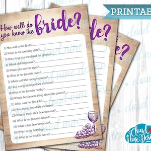 Op de afbeelding: Printbare spelkaart met een houtnerf achtergrond en paarse tekst die "How well do you know the bride?" luidt, met 17 vragen over de bruid. De kaart heeft een afbeelding van druiven en wijnglazen.