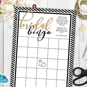 Op de afbeelding: Zwart-wit gestreepte bruiloftbingo-kaart met gouden glittertekst die "bridal bingo" zegt. Instructies voor het spelen van het spel zijn inbegrepen.