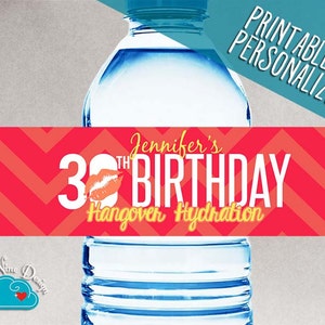 Op de afbeelding: Printbare waterfleslabel met een rood en oranje chevron-patroon. Het label zegt "Jennifer's 30th Birthday Hangover Hydration" in witte en gele tekst.