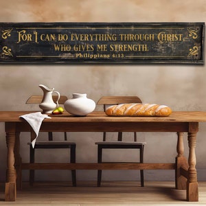 May include: A rustic wooden sign with black paint and gold lettering. The sign reads "For I can do everything through Christ who gives me strength. Philippians 4:13".