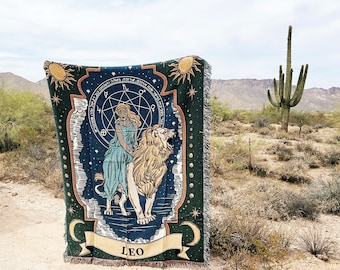 Puede incluir: Un tapiz verde, azul y dorado con un león y una mujer con un vestido azul. El tapiz tiene un diseño de estrella y la palabra "LEO" en la parte inferior.