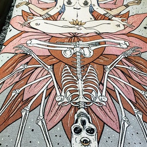May include: A tapestry featuring a multi-armed goddess figure sitting in a lotus position atop a skeletal figure with a skull. The goddess has a third eye and is surrounded by stars. The tapestry is woven with a variety of colors, including pink, brown, and gray.