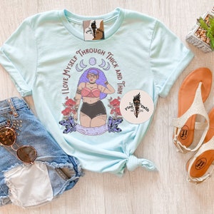 Puede incluir: Camiseta azul claro con un gr&aacute;fico de una mujer con cabello morado y un mensaje positivo sobre el cuerpo que dice "Me amo a m&iacute; misma en la gordura y en la delgadez".