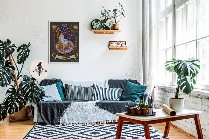 May include: A framed illustration of the zodiac sign Scorpio. The illustration features a woman sitting on a scorpion with a starry background. The text "Scorpio" is written in a banner below the image.