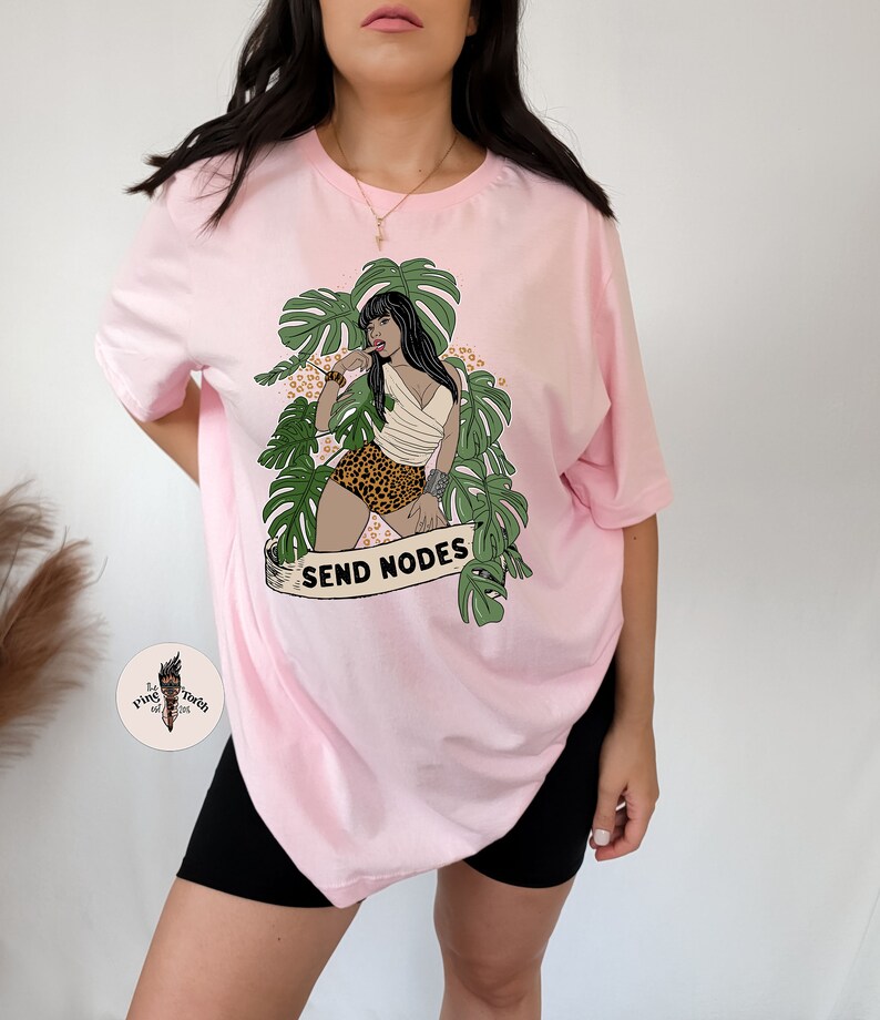 K&ouml;nnte beinhalten: Rosa, &uuml;bergro&szlig;es T-Shirt mit einem Aufdruck einer Frau in einer Dschungelkulisse mit dem Text "SEND NODES".