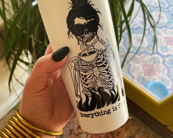 May include: White stainless steel tumbler with a black and white illustration of a skeleton wearing sunglasses and a bun, drinking from a cup. The text "Everything is fire" is printed on the tumbler.