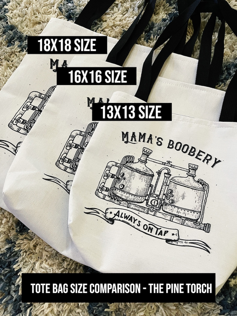 May include: Three white canvas tote bags with black handles and black text. The bags are stacked on top of each other, with the largest bag on the bottom. The bags are labeled with the sizes 18x18, 16x16, and 13x13. The smallest bag has a black and white illustration of a brewery with the text "Mama's Boobery" and "Always on Tap".