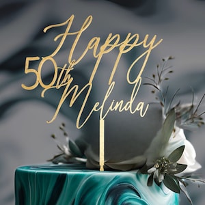 May include: Gold glitter cake topper with the text "Happy 50th Melinda" on a green and white marbled cake.