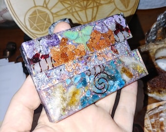 May include: A multi-layered resin paperweight with a variety of crystals, including amethyst, rose quartz, and clear quartz. The paperweight also features a copper wire spiral and a green butterfly.