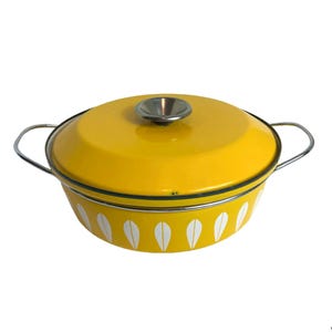 May include: Yellow enamel Dutch oven with a white leaf pattern and a silver lid.