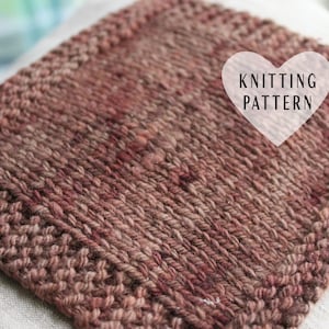 以下が含まれることがあります： 茶色と赤の色合いのニット生地のクローズアップ。生地は、手編みの質感があります。ハート型の背景に白い文字で「Knitting Pattern」と書かれています。