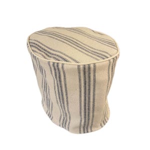 May include: A cream-coloured fabric kitchen appliance cover with blue stripes. The cover is round and has a white trim around the top edge.