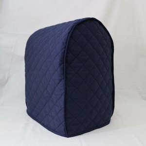 May include: A navy blue quilted cover for a stand mixer. The cover has a diamond pattern and is designed to protect the mixer from dust and spills.