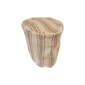 May include: A white and brown striped fabric cover for a kitchen appliance. The cover has a white trim around the top edge.