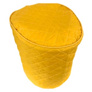 May include: A yellow quilted kitchen appliance cover with a diamond pattern.