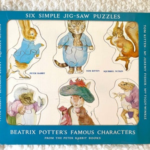 May include: A vintage jigsaw puzzle featuring six characters from Beatrix Potter's books, including Peter Rabbit and Tom Kitten. The puzzle pieces are shaped like the characters and are set against a light background with a blue border. The text "SIX SIMPLE JIG-SAW PUZZLES" is visible.