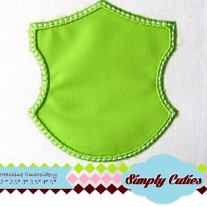 Może przedstawiać: Zielony materiałowy tarcza z białą, pikowaną krawędzią. Tarcza jest pusta i można ją spersonalizować za pomocą haftu. Rozmiary haftu maszynowego są wymienione: 2 cale, 2,5 cala, 3 cale, 3,5 cala, 4 cale i 5 cali.