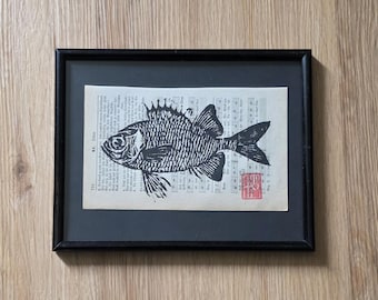 Hand-printed linocut on a vintage hymnal page - Soldier Fish
