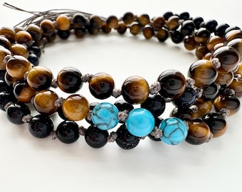 May include: A multi-strand beaded necklace with brown tiger's eye beads, black beads, and turquoise beads.