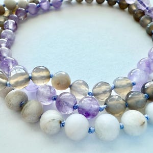 May include: A multi-strand necklace made of amethyst, white agate, and grey agate beads. The beads are all round and have a smooth, polished finish.