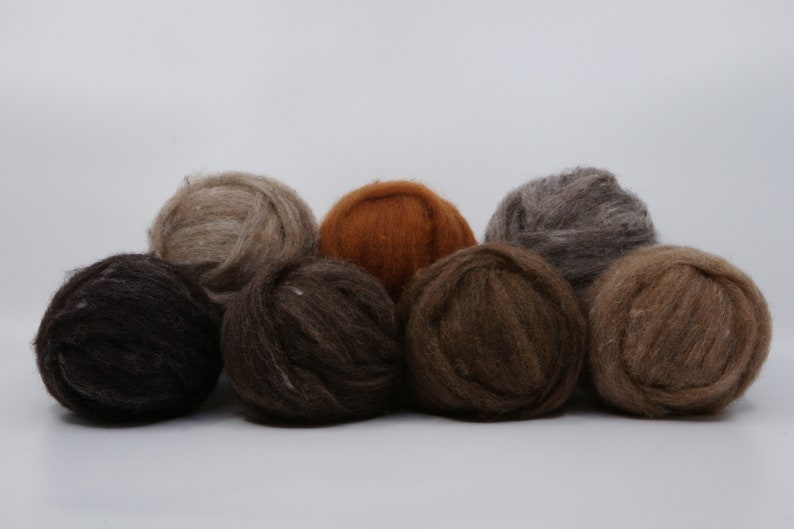 May include: A collection of eight balls of yarn in various shades of brown, from dark chocolate to light tan. The yarn appears soft and fluffy, ideal for knitting or crocheting projects.