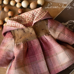 May include: A red, brown, and white plaid hooded jacket with a cream and red checkered lining. The jacket is made of a soft, textured fabric and has a vintage look.