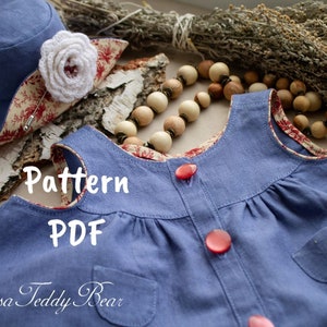 May include: A blue and red fabric pattern for a sleeveless dress with a pocket and buttons. The text "Pattern PDF" is visible on the fabric. The text "Teddy Bear" is visible at the bottom of the image.