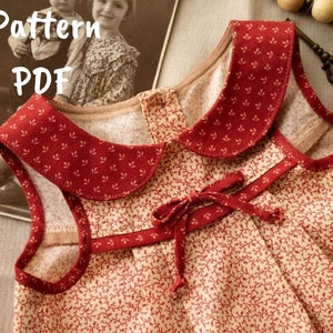 May include: A red and white floral print sleeveless dress with a red collar and a red bow at the waist. The dress has a pattern of small red leaves on a white background. The dress is made of a soft, lightweight fabric. The dress is perfect for a summer day.