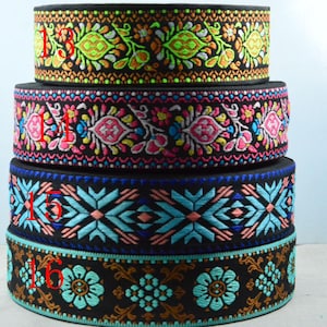 Könnte beinhalten: Vier Stapel dekorativer, bestickter Bänder. Das obere Band hat einen schwarzen Hintergrund mit neongrünen, orangefarbenen und gelben Blumenmustern. Das zweite Band hat rosa, blaue und weiße Blumenmuster. Das dritte Band hat blaue und pfirsichfarbene geometrische Muster. Das untere Band hat braune und türkisfarbene Blumenmuster.