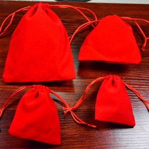 Puede incluir: Cuatro bolsitas de terciopelo rojo con cordón de diferentes tamaños. Las bolsitas están hechas de terciopelo suave y afelpado y tienen un cierre de cordón.