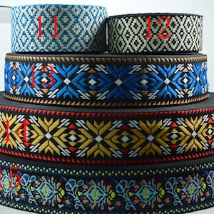 Puede incluir: Una pila de cintas decorativas tejidas en varios anchos y patrones. Las cintas presentan diseños geométricos y florales en colores como azul, negro, amarillo y blanco. Cada cinta está numerada en rojo.