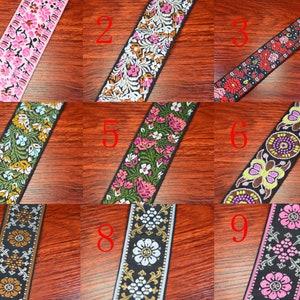 May include: Nine different patterned ribbon trims with various floral and geometric designs. The ribbons are black with colorful accents, including pink, green, yellow, and blue.