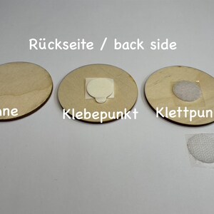 May include: Three round wooden discs with different backings. The first disc has no backing, the second disc has a sticky adhesive dot, and the third disc has a hook and loop fastener.