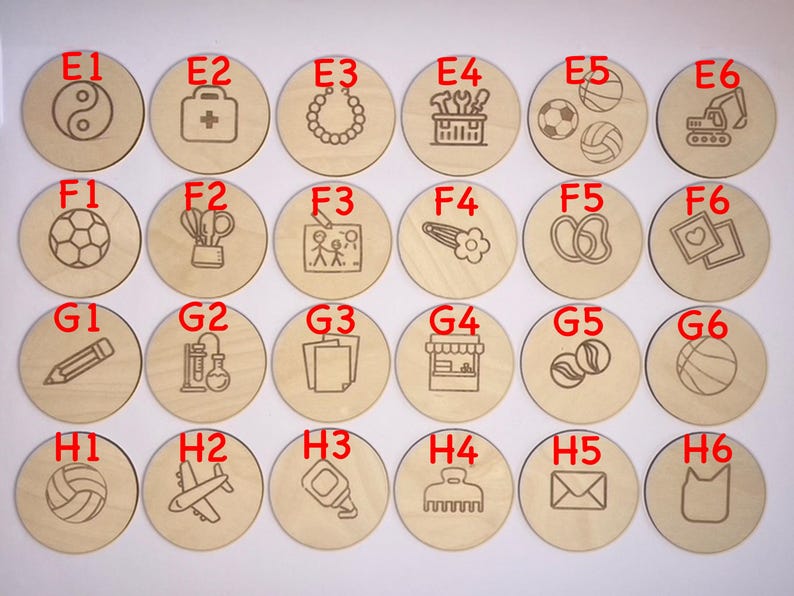 May include: Set of 36 wooden circles with different images and letters. The circles are arranged in a grid of six rows and six columns. Each circle has a letter and a corresponding image. The images include a yin yang symbol, a first aid kit, a necklace, a toolbox, a soccer ball, a construction vehicle, a soccer ball, a pair of scissors, a family, a hair clip, a pair of flip flops, a heart, a pencil, a test tube, a stack of papers, a store front, a marble, a basketball, a volleyball, an airplane, a glue bottle, a comb, an envelope, and a cat.