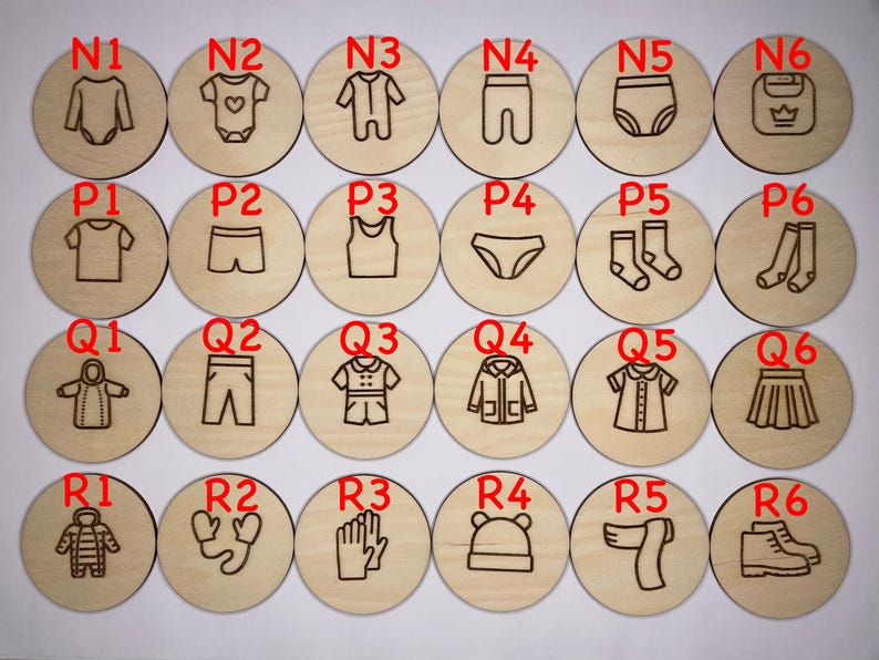 May include: Twenty-four wooden circles with different clothing items and accessories engraved on them. The circles are labeled with letters and numbers, such as N1, P2, Q3, and R4.