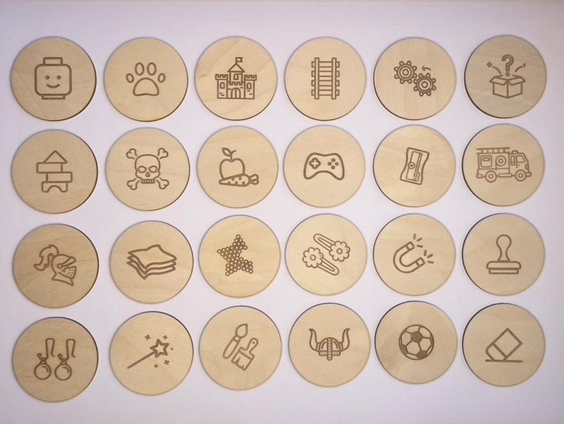 May include: Set of 18 wooden circles with various engraved images, including a castle, a paw print, a skull and crossbones, a game controller, a fire truck, a knight's helmet, a stack of paper, a star, a magnet, a stamp, a pair of earrings, a magic wand, paintbrushes, a viking helmet, a soccer ball, and an eraser.