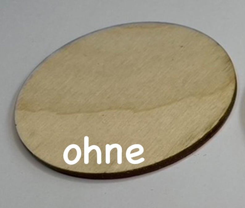 May include: A round, wooden disc with a smooth, light brown surface. The word "ohne" is printed in white on the disc.