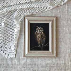 May include: A framed painting of a brown and white owl with yellow eyes, perched on a branch against a dark background. The painting is signed "Malinowsky" in the bottom left corner.