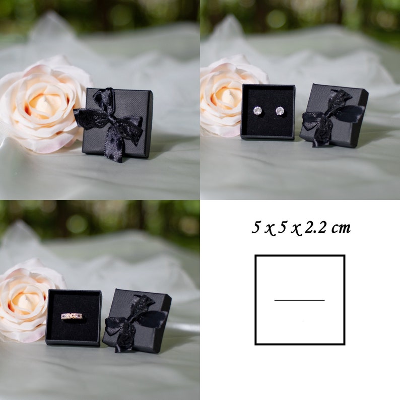 May include: Two black gift boxes with black ribbon bows. One box contains a pair of small silver earrings. The other box contains a silver ring. The boxes are 5 x 5 x 2.2 cm.