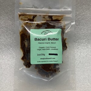 Könnte beinhalten: Ein klarer Plastikbeutel mit Bacuri-Butter. Der Beutel hat ein grünes Etikett mit der Aufschrift "Bacuri Butter" und weiteren Details. Die Butter ist dunkelbraun und scheint fest zu sein. Das Etikett gibt 28g an.