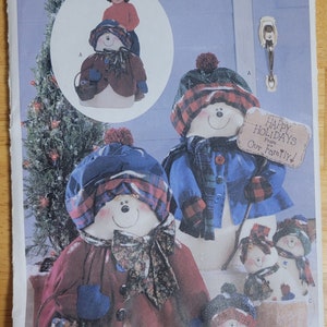 Puede incluir: Un patrón de costura para hacer cinco figuras de muñeco de nieve. El patrón es de Butterick y se llama Luv 'N Stuff. El patrón incluye una niña pequeña de pie junto a un muñeco de nieve, y otros cuatro muñecos de nieve de diferentes tamaños. Los muñecos de nieve están vestidos con tela roja, azul y a cuadros. Los muñecos de nieve sostienen cestas, letreros y palos. El patrón es para una sola talla.