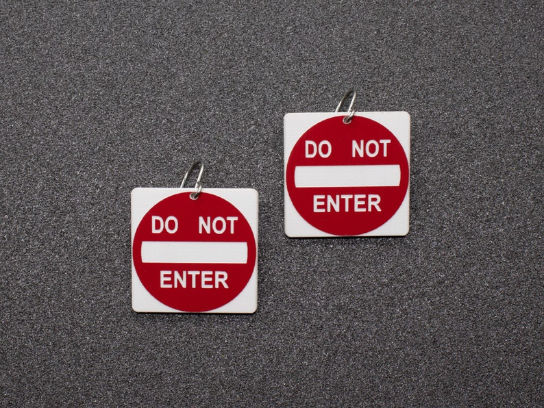 May include: Two white square signs with red borders and the text "DO NOT ENTER" in black letters.