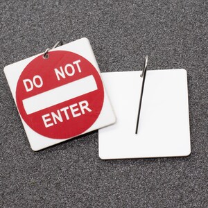 May include: A red and white sign with the text "Do Not Enter" on a gray background. The sign is attached to a blank white tag with a metal ring.