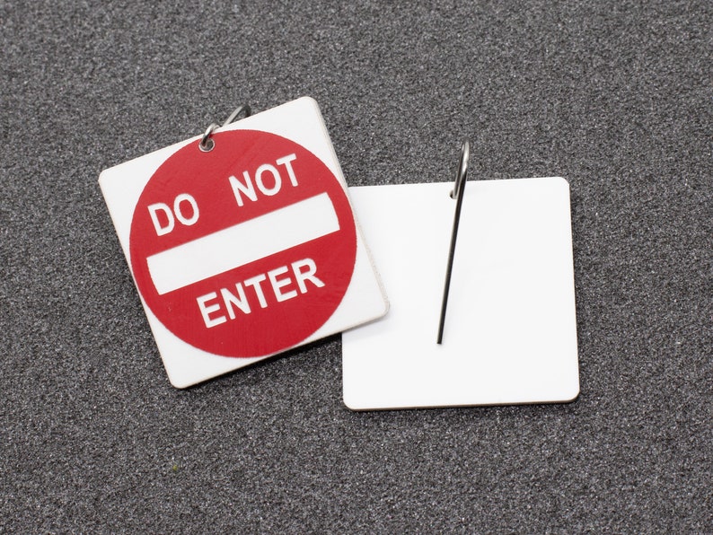 May include: A red and white sign with the text "Do Not Enter" on a gray background. The sign is attached to a blank white tag with a metal ring.
