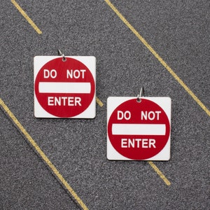May include: Two red and white "Do Not Enter" signs with a white bar across the middle. The signs are on a gray background.