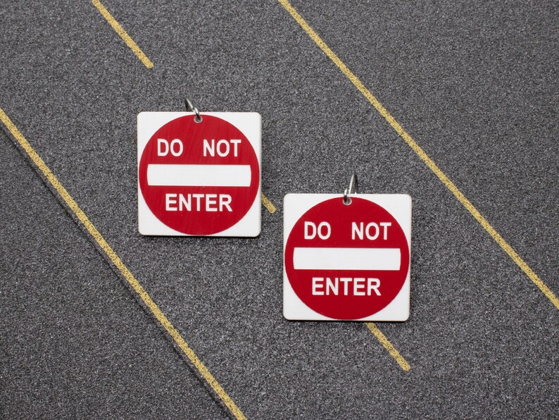 May include: Two red and white "Do Not Enter" signs with a white bar across the middle. The signs are on a gray background.