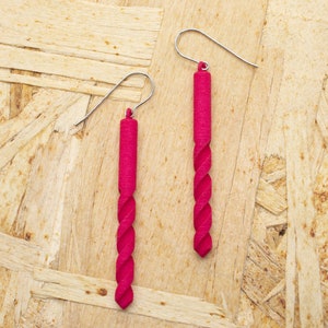 May include: A pair of long, pink, twisted earrings with silver hooks.