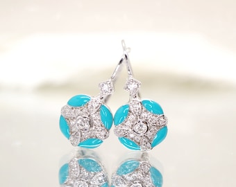 Puede incluir: Un par de pendientes colgantes de plata con esmalte azul turquesa y piedras de circonita cúbica transparentes.