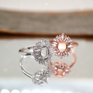 Puede incluir: Dos anillos de plata con un engaste de piedra transparente. Los anillos est&aacute;n adornados con peque&ntilde;as piedras transparentes que crean un dise&ntilde;o de sol. Un anillo es de oro rosa.
